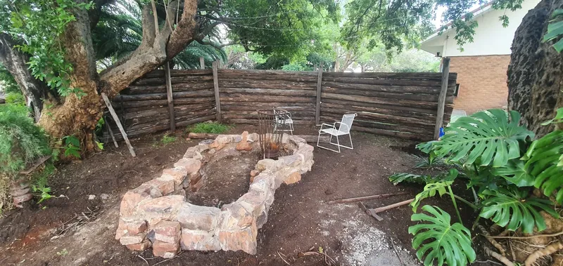 Outdoor Stone Boma Firepit with Log Fence